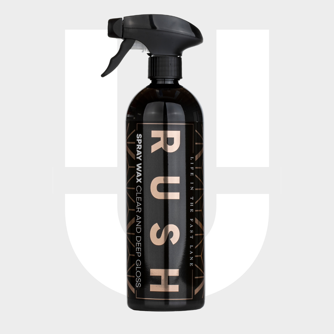 A black spray bottle labeled 1+1 GRATIS Spray Wax, designed with nanotechnologie for lak bescherming, stands upright on a light gray background with a faint logo behind it.