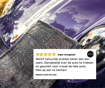 A close-up of the Master Drying Towel 1200 GSM in grey on a purple Porsche hood. Overlaid is a Dutch 5-star review praising this droogdoek auto’s cleaning effectiveness and user-friendly design for the whole car.