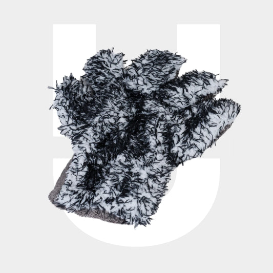 A black and white textured Wash Glove made from microvezel with shaggy fibers lies on a light gray surface, with a large white stylized "U" in the background—ideal for cleaning car paint (autolak reinigen).