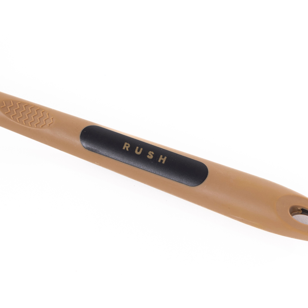 Close-up of the Detail Brush Set: tan plastic handle with black grip, RUSH in gold letters. Perfect for auto schoonmaken, it features zachte zwijnenharen borstels and a textured pattern on one end.