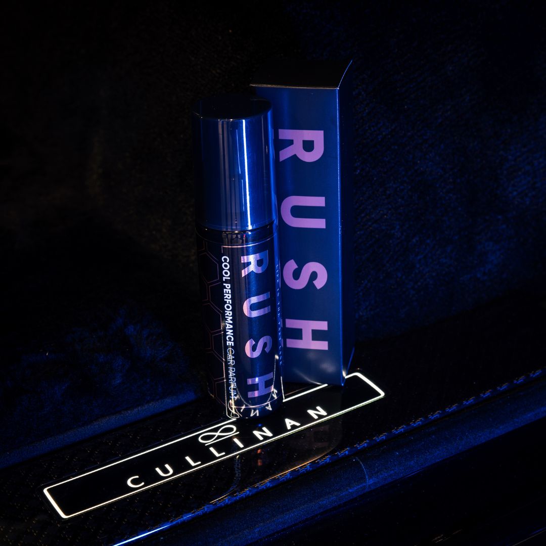 A bottle labeled Cool Performance - 125 ml and its matching box, both lit by blue light on a CULLINAN surface with the Rolls-Royce logo—perfect for those seeking een langdurige geur car parfum experience.