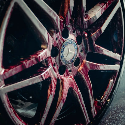 Close-up of a Mercedes-Benz wheel with red liquid, possibly from the Try Out Package, streaking down the spokes and creating a dramatic, intense look.