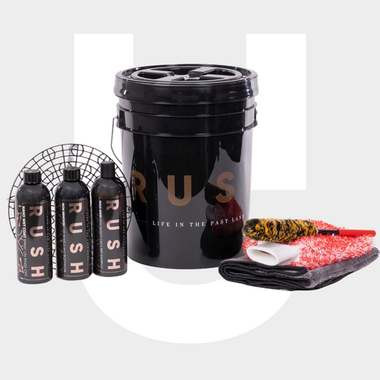 The Wasbox Package includes a large black bucket, three cleaning solutions, a black grid, yellow and black brush, red and white wash mitt, and two microfiber towels—ideal for any wasbox.