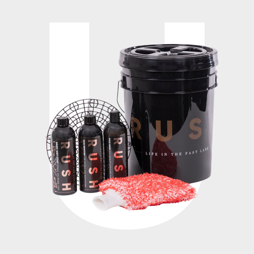 A black Exterior Package wash bucket with three matching bottles, a red and white microfiber wash mitt, and a black grit guard—everything you need for professionele auto reiniging—arranged on a light background.